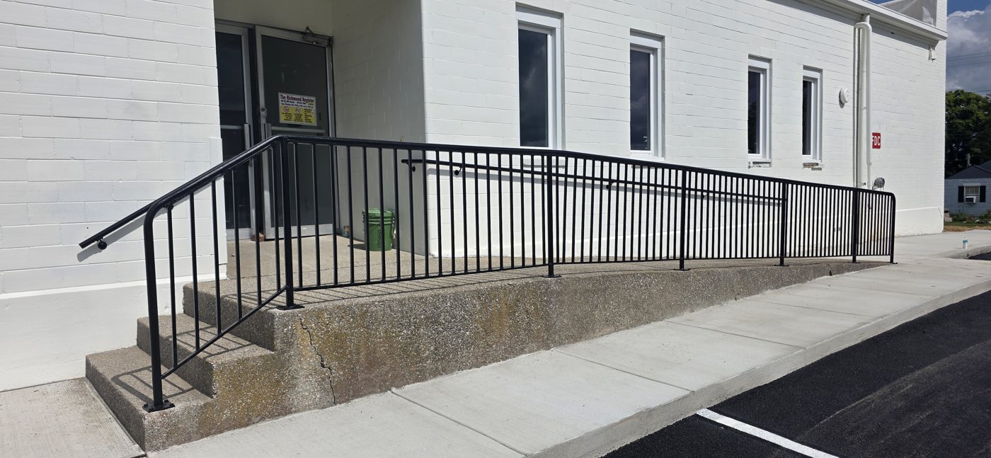 Black steel ADA handrail along a commercial building ramp