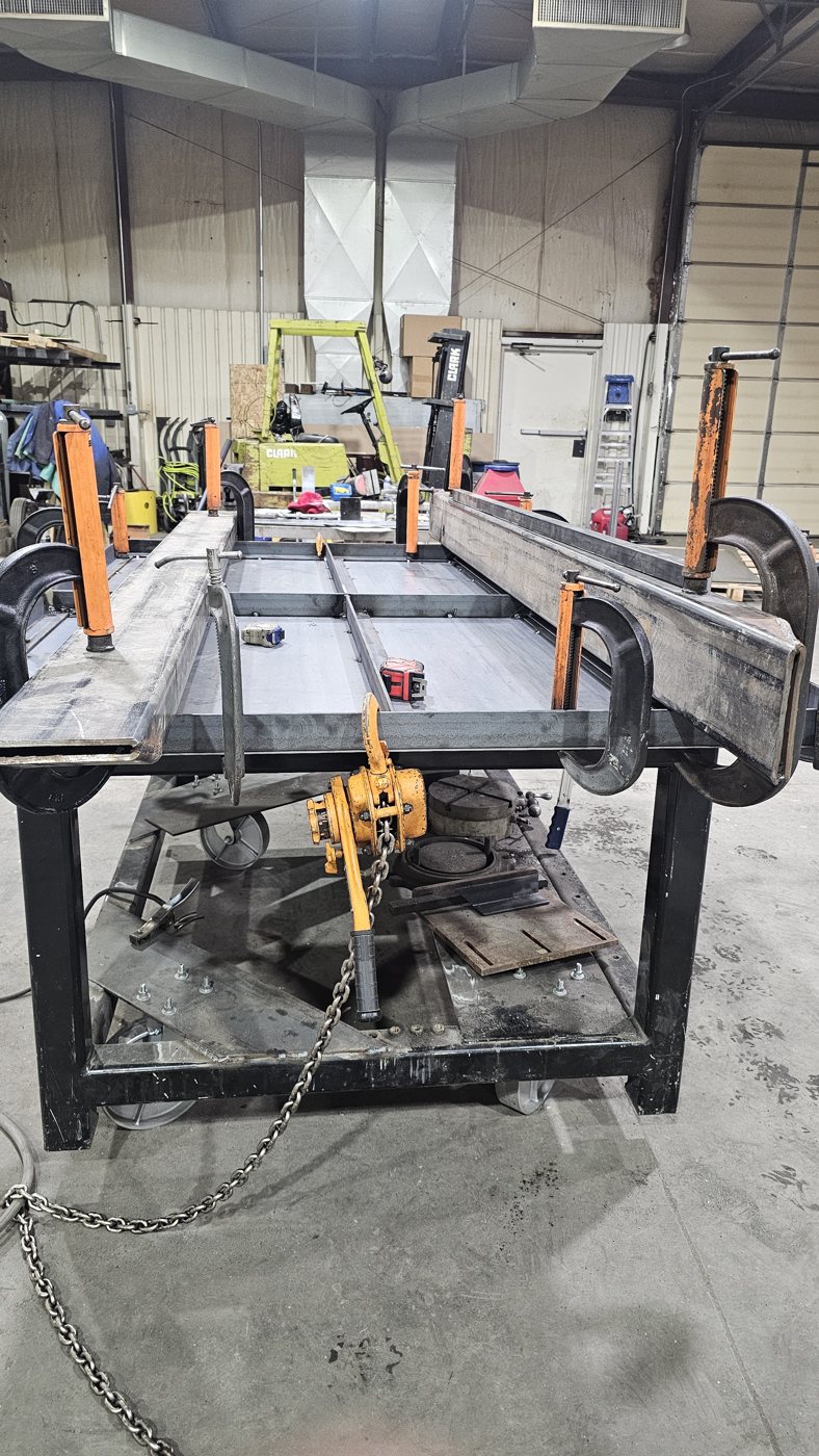 Unpainted steel skid front view with clamps in the shop