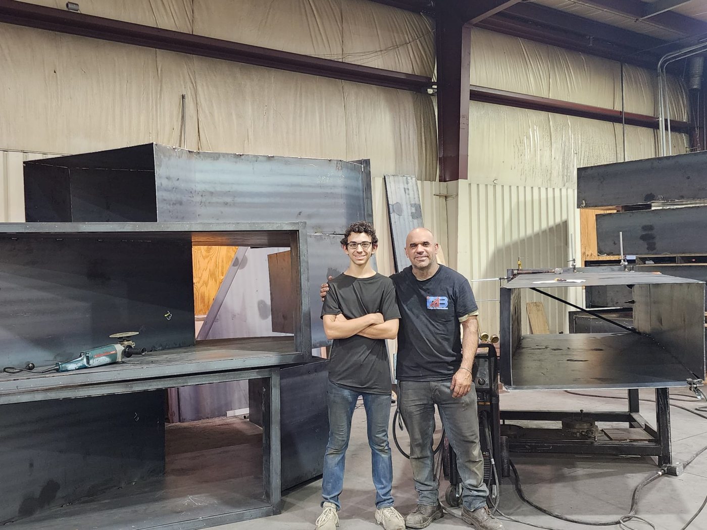 iFab team in the shop with unpainted steel hoppers
