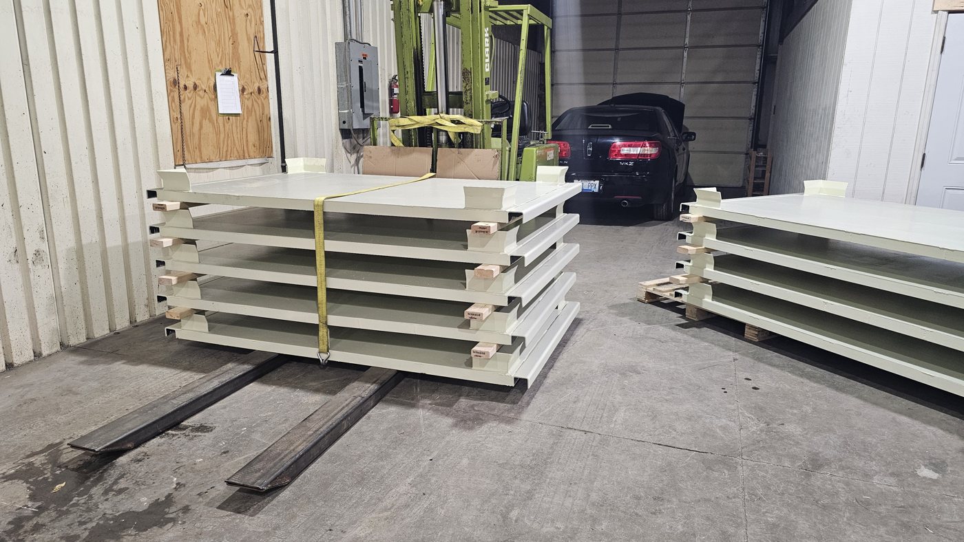 Stacked painted steel skids for automotive manufacturing, ready for shipment