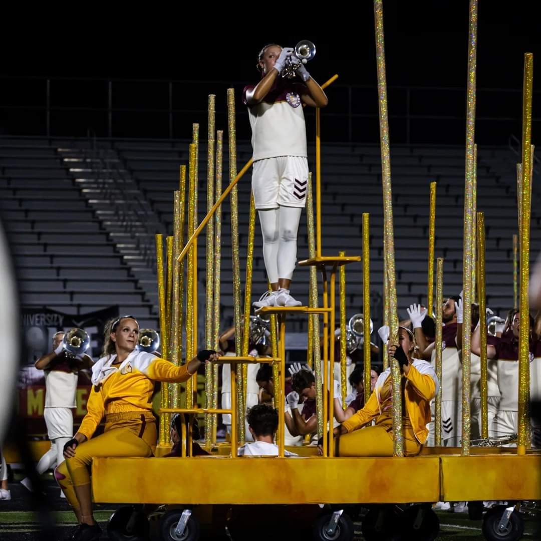 Cadets performer playing trumpet atop the curved soloist steps prop