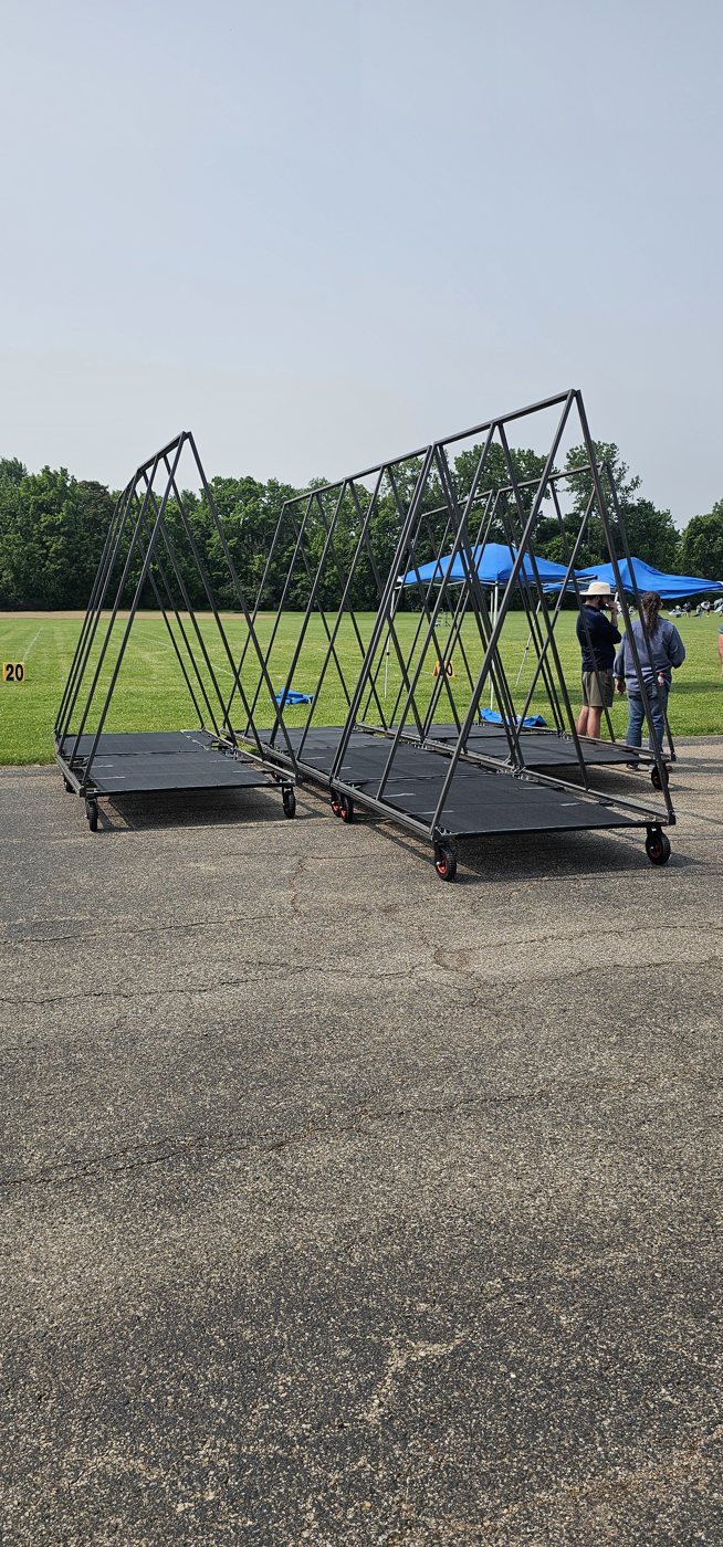 Collapsible frames staged for load-in on the practice field